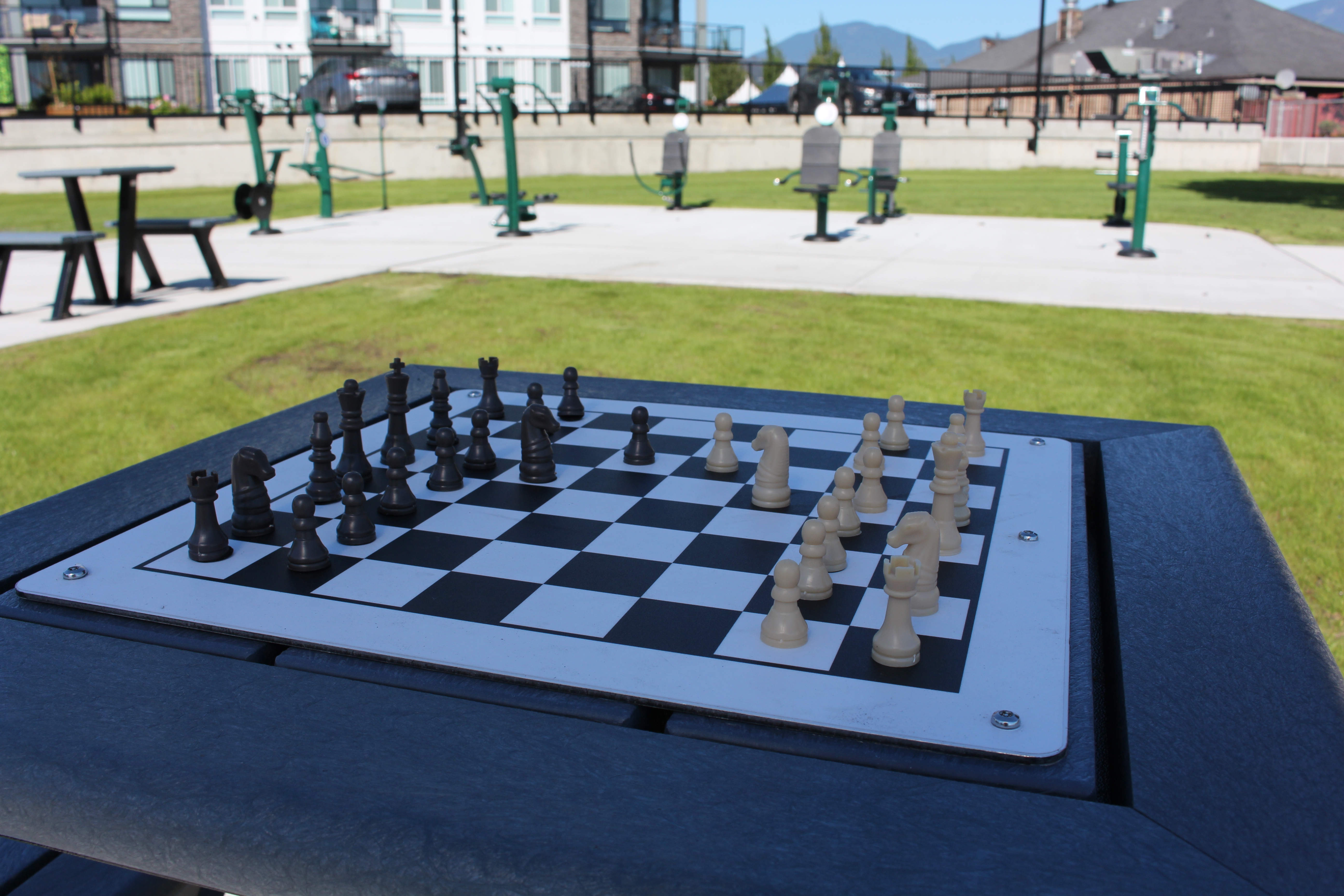 An outdoor chess table set up and ready for a game.